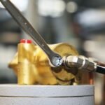 A Beta Tools 3/4-inch combination wrench in use on a brass hydraulic fitting, highlighting its secure grip and smooth torque delivery. Get it at Wrenchers.com.