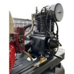 Close-up of Industrial Gold CI3GEH30 compressor pump assembly, showcasing the heavy-duty cooling fins, braided lines, and durable cast-iron build. Get it at Wrenchers.com
