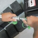 Hands connecting QuickJack BL-3500SLX hydraulic fittings using tool-free quick couplers. Built for reliability, speed, and repeat use in home or professional shop settings.