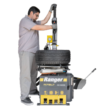Operator using the Ranger R76LT tire changer to service a stacked tire assembly, demonstrating ergonomic controls and hands-on workflow