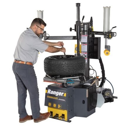 Technician using the R980DP bead lifting tool for precise demounting of stiff sidewall tires. Built to reduce effort while protecting wheels during service. SKU 5140174.
