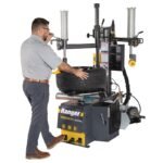 Operator using the R980DP tire changer with dual assist arms for faster, safer tire changes. Designed to handle low-profile, run-flat, and performance tires with confidence. SKU 5140174.
