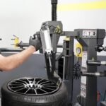 Leverless tire changer accessory in action, showcasing precision bead lifting and safer wheel handling without prybars.