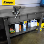 Ranger RWB-2D workbench installed in an automotive shop with tools, cleaning supplies, and a vise mounted on the tabletop